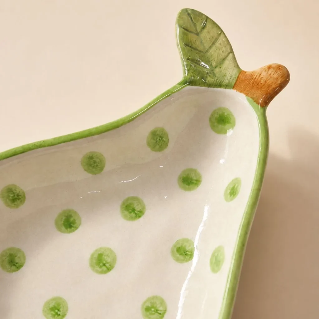 Handcrafted Green Polka Dot Pear Bowl with Leaf Handle styled in a home setting